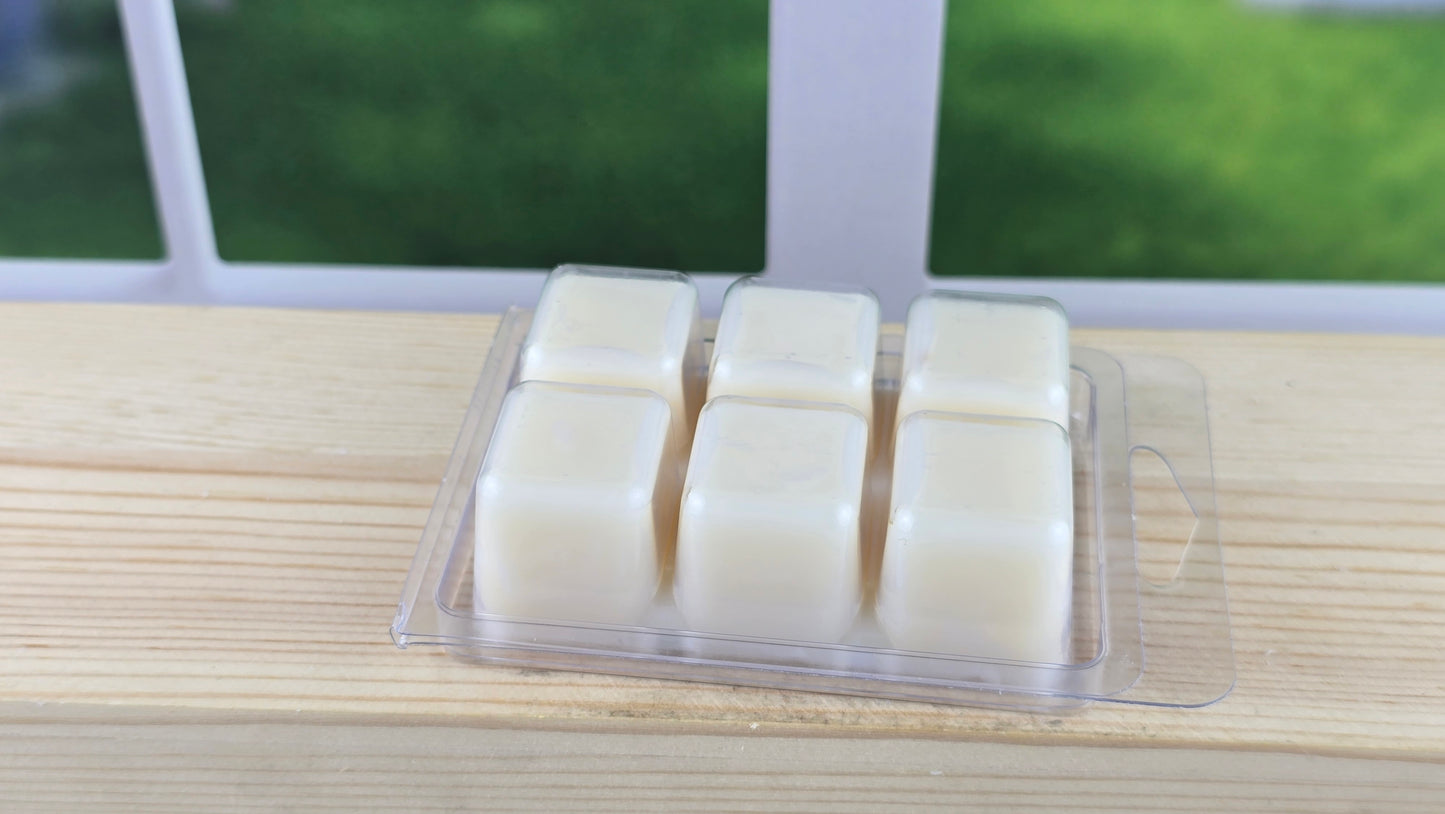 clamshell wax melt laying on wooden surface showing the back 