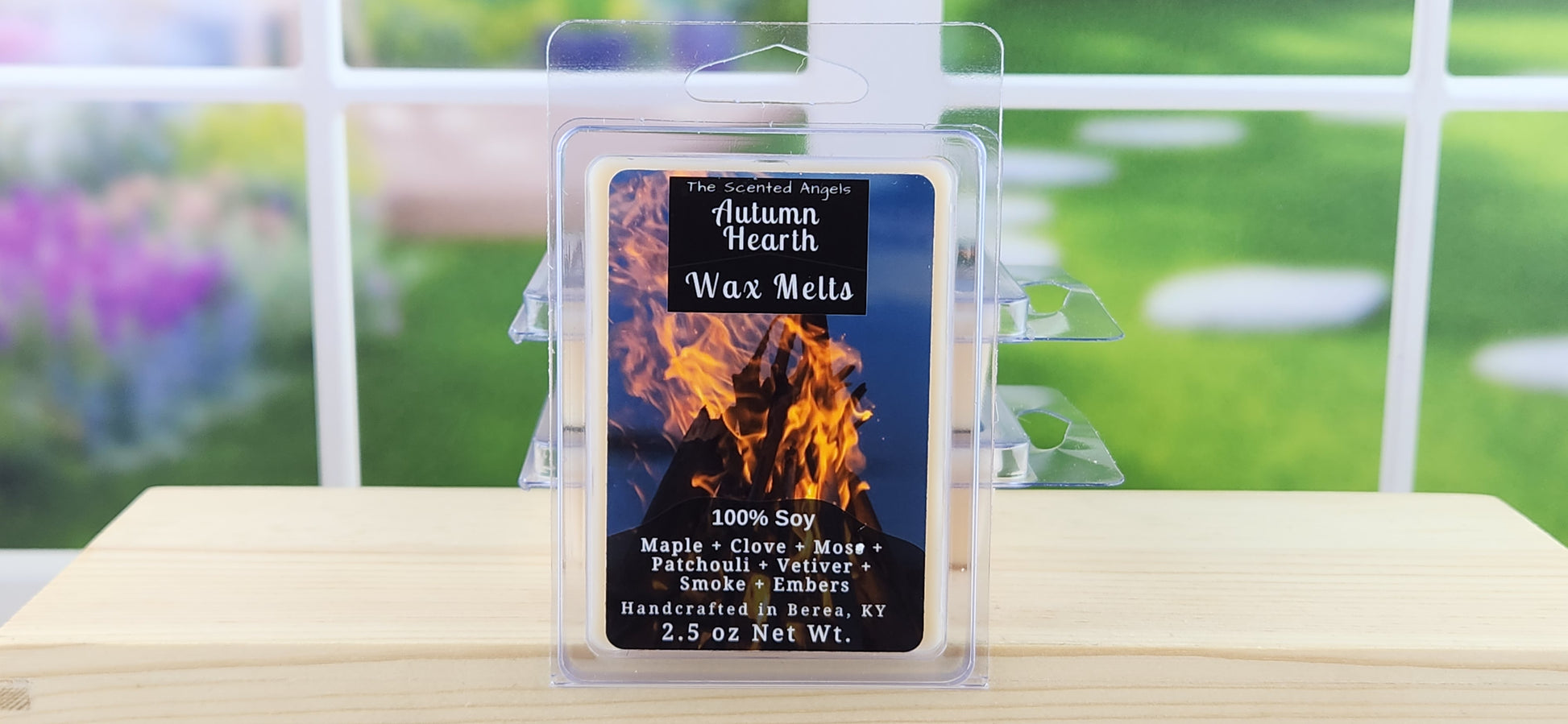 Autumn Hearth Wax Melts packaging on a wooden surface with a blurred outdoor background