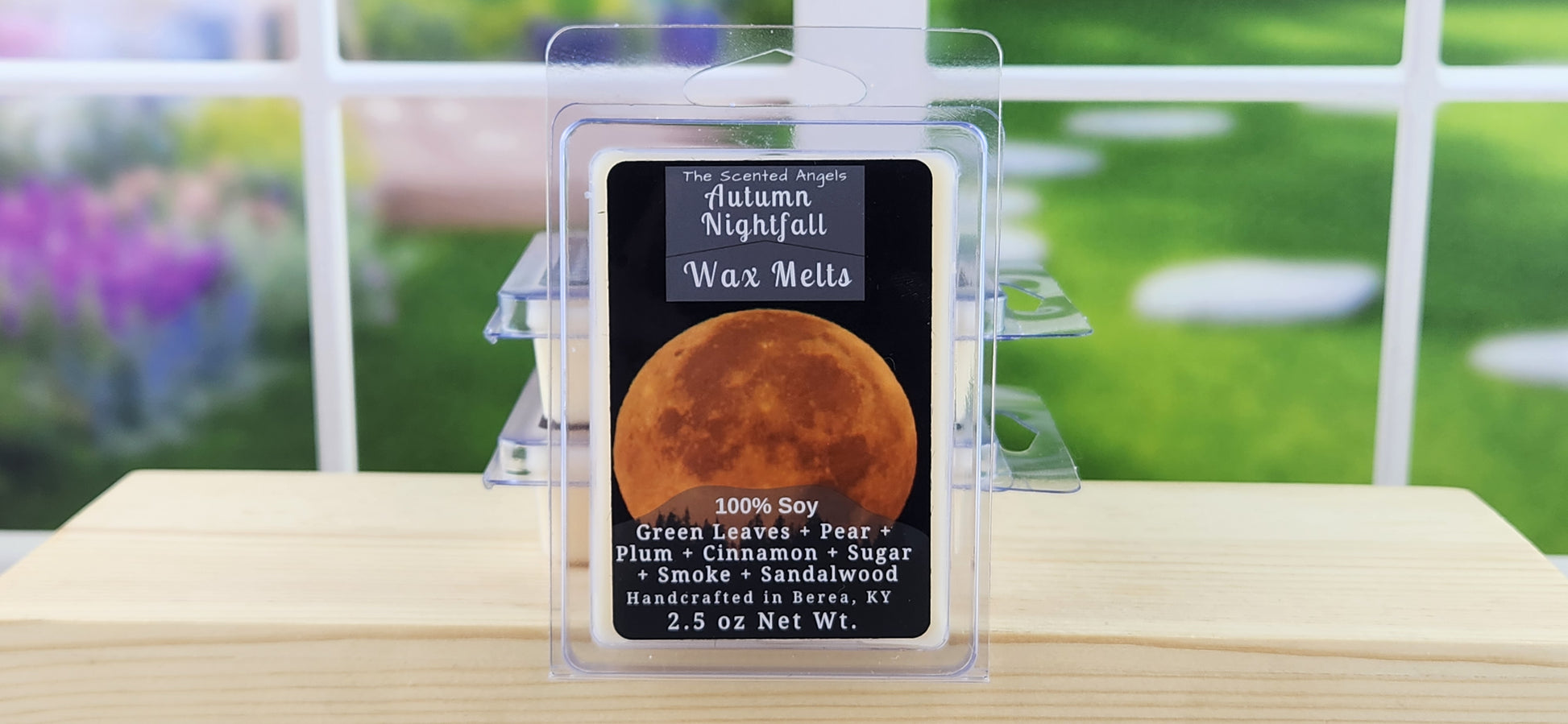 Wax melt packaging with label on a wooden surface, outdoor background