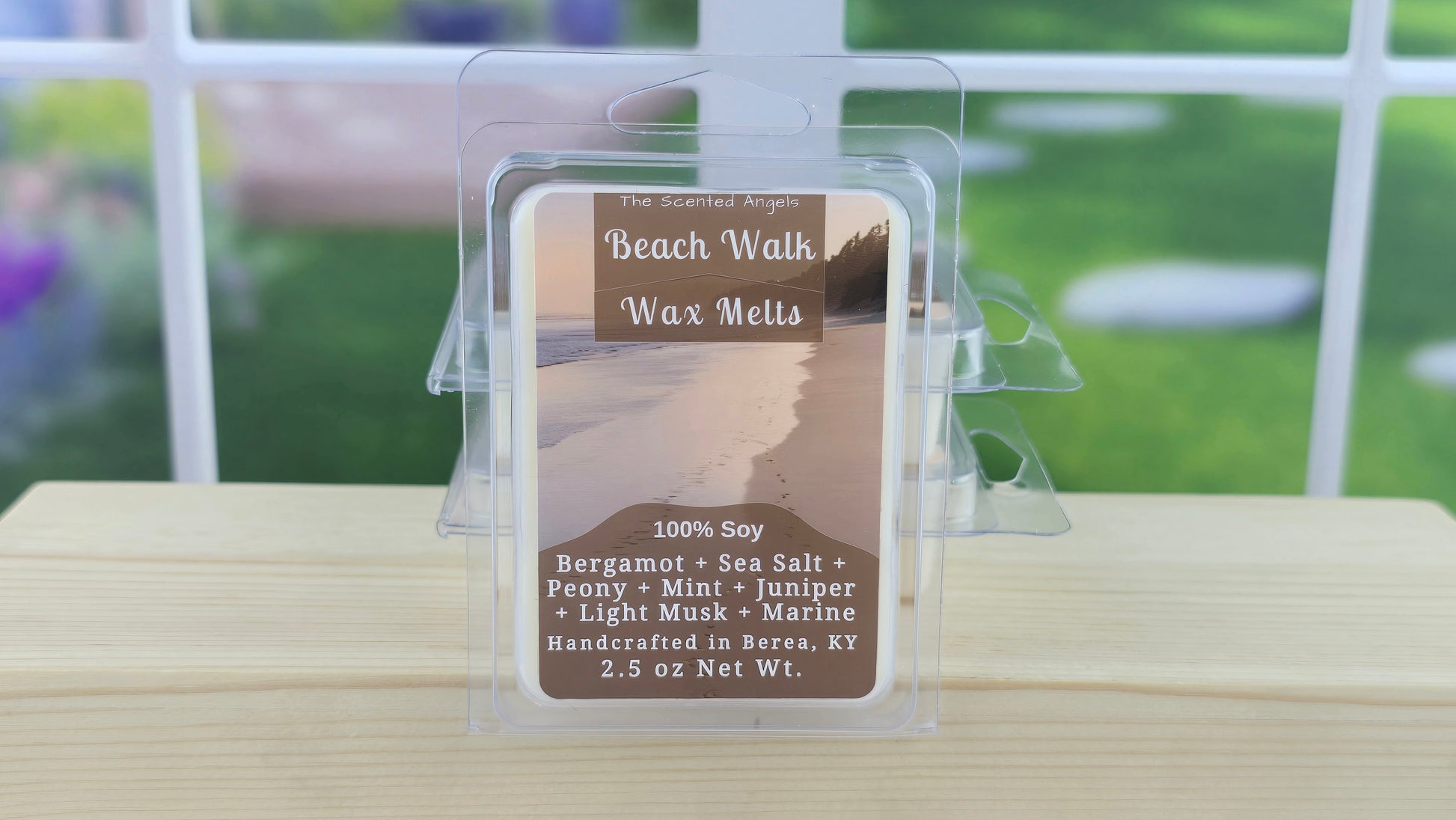 Beach Walk wax melt packaging on a wooden surface with a blurred outdoor background