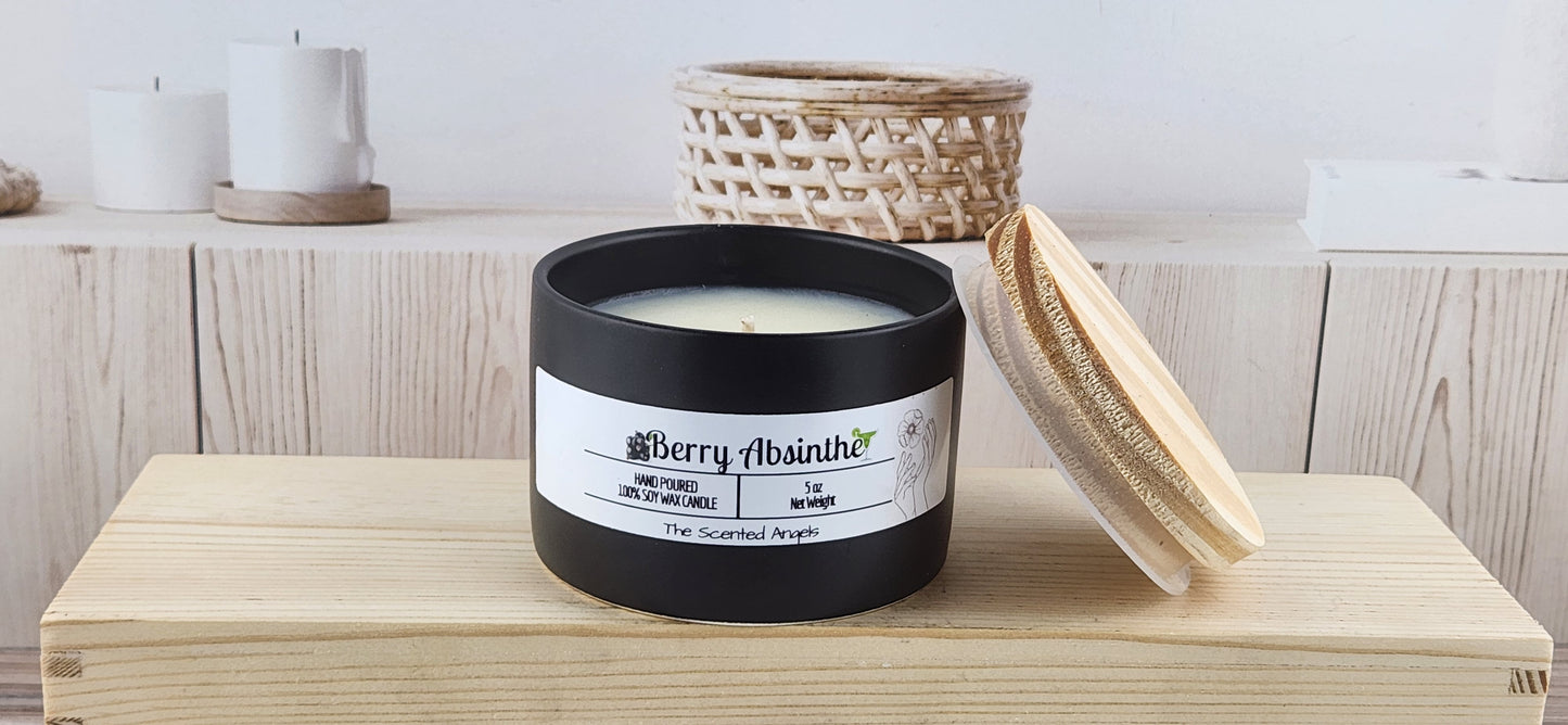 Black candle with a white label on a wooden surface, surrounded by wicker baskets and candles.