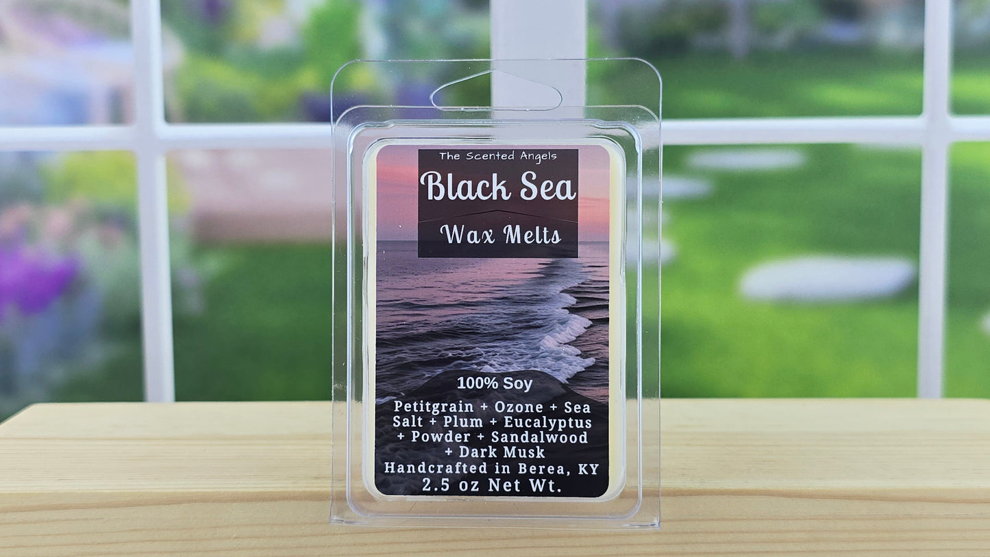 Packaged Black Sea wax melts on a wooden surface with a blurred outdoor background
