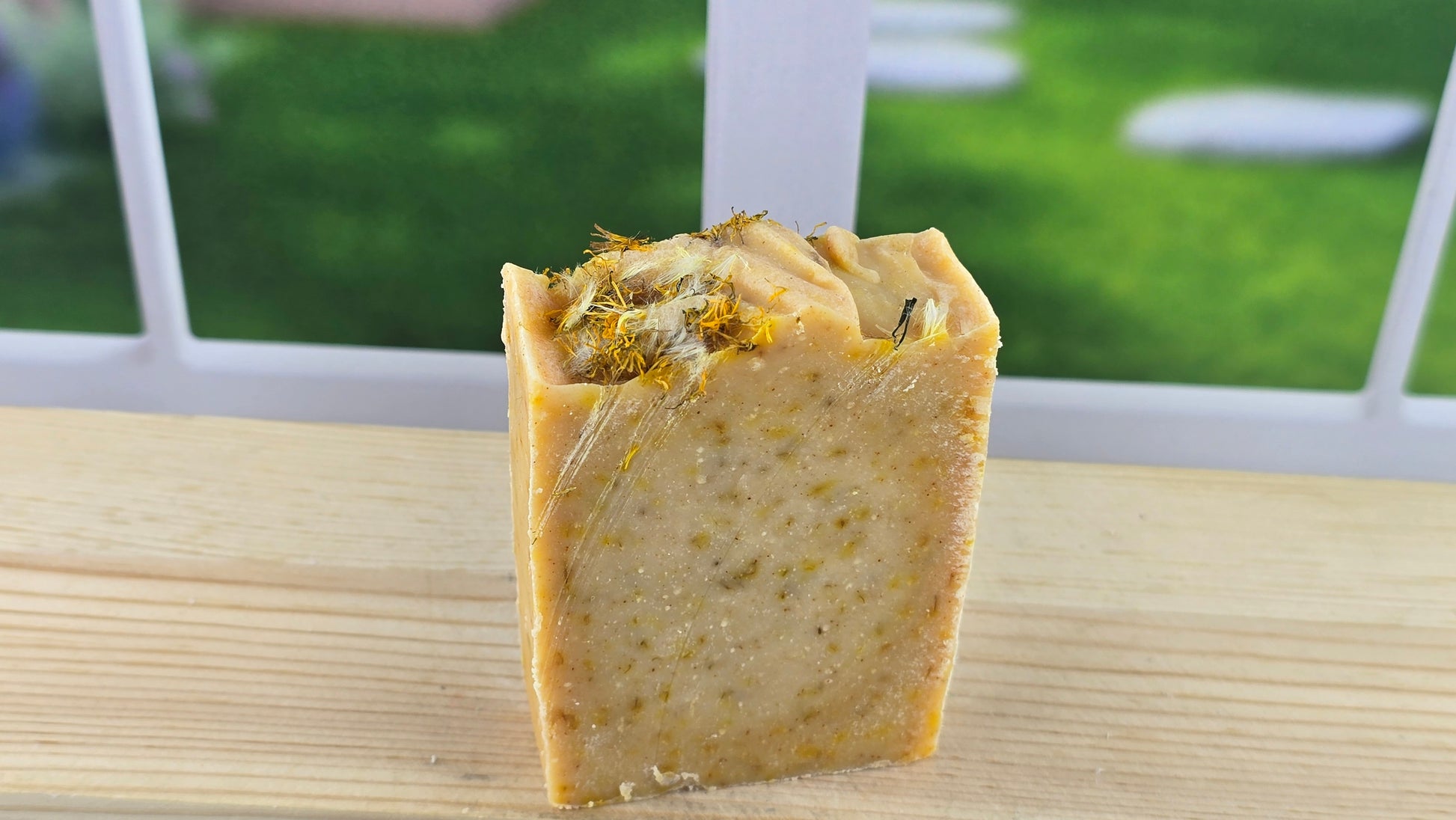 An Orange Dandelion Soap sitting on a woooden surface