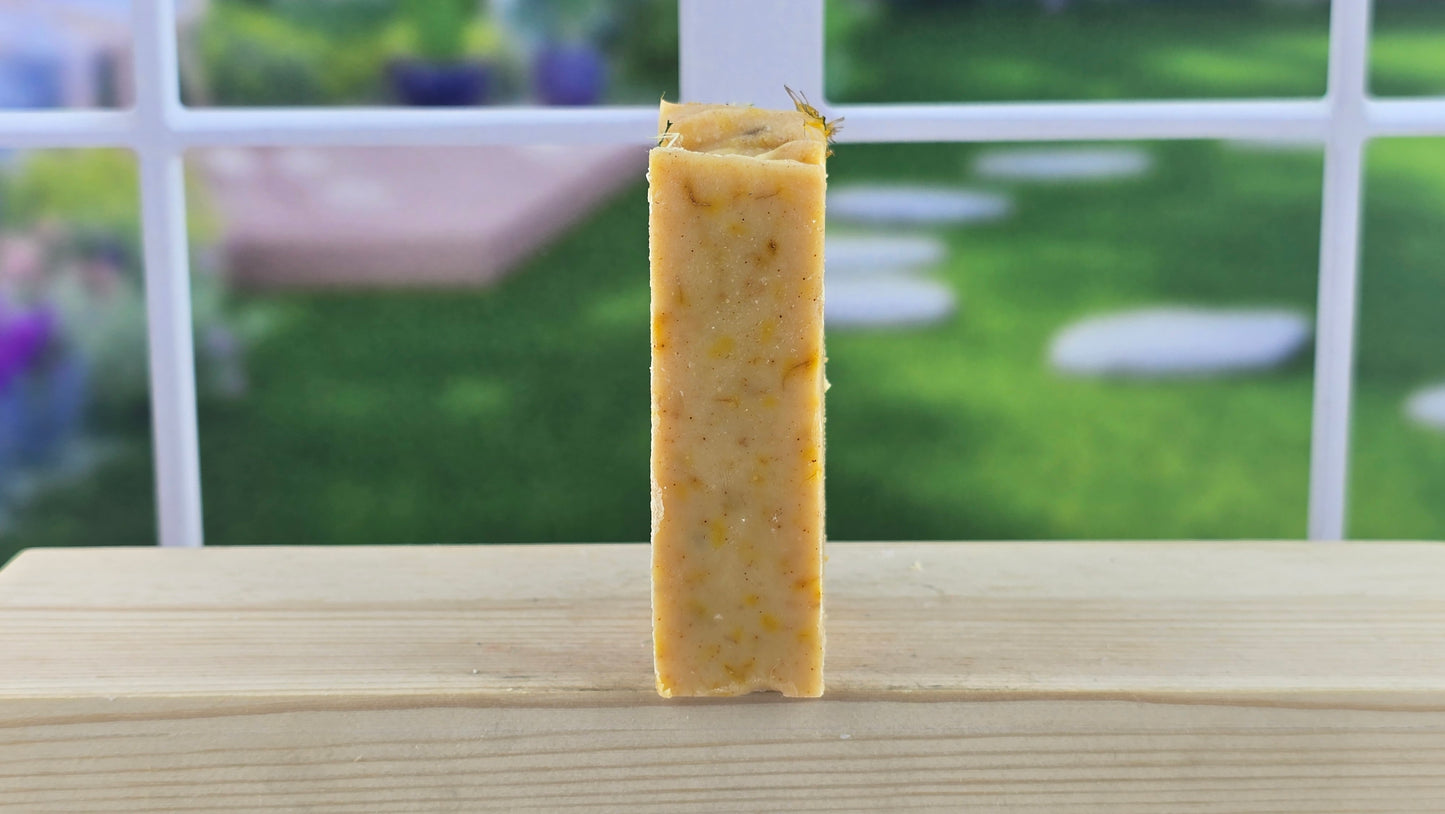 Side view of a Blood Orange Dandelion Soap on a wooden surface