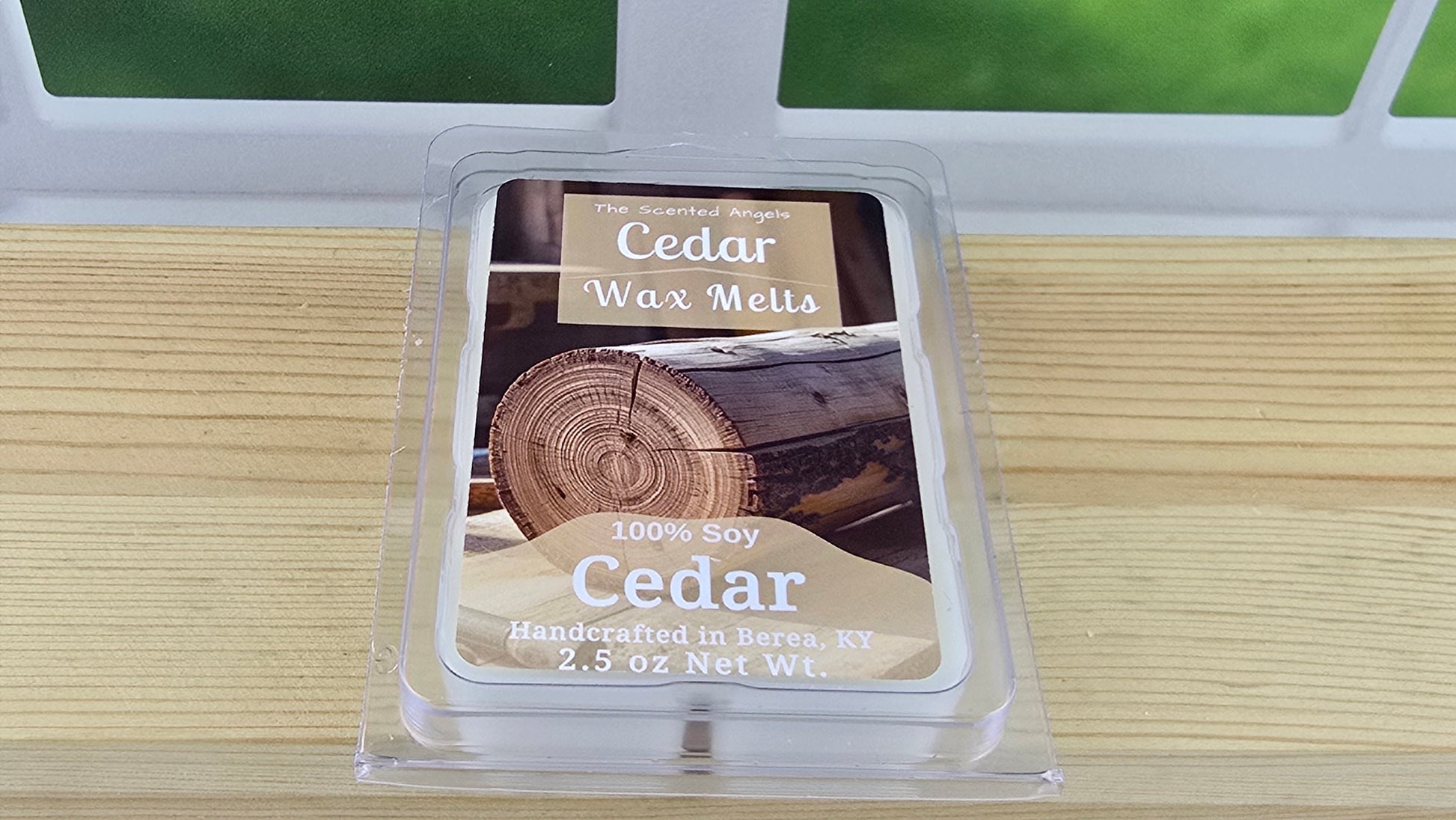 Pack of Cedar Wax Melts on a wooden surface with a blurred green background