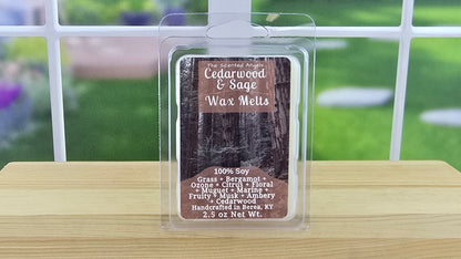 Cedarwood & Sage wax melt package on a wooden surface with a blurred outdoor background