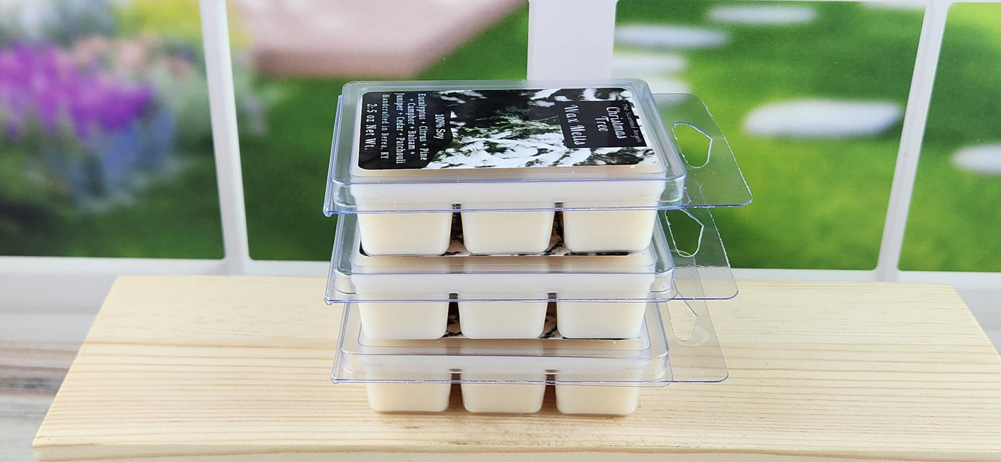 Packaged wax melts on a wooden surface with a blurred outdoor background