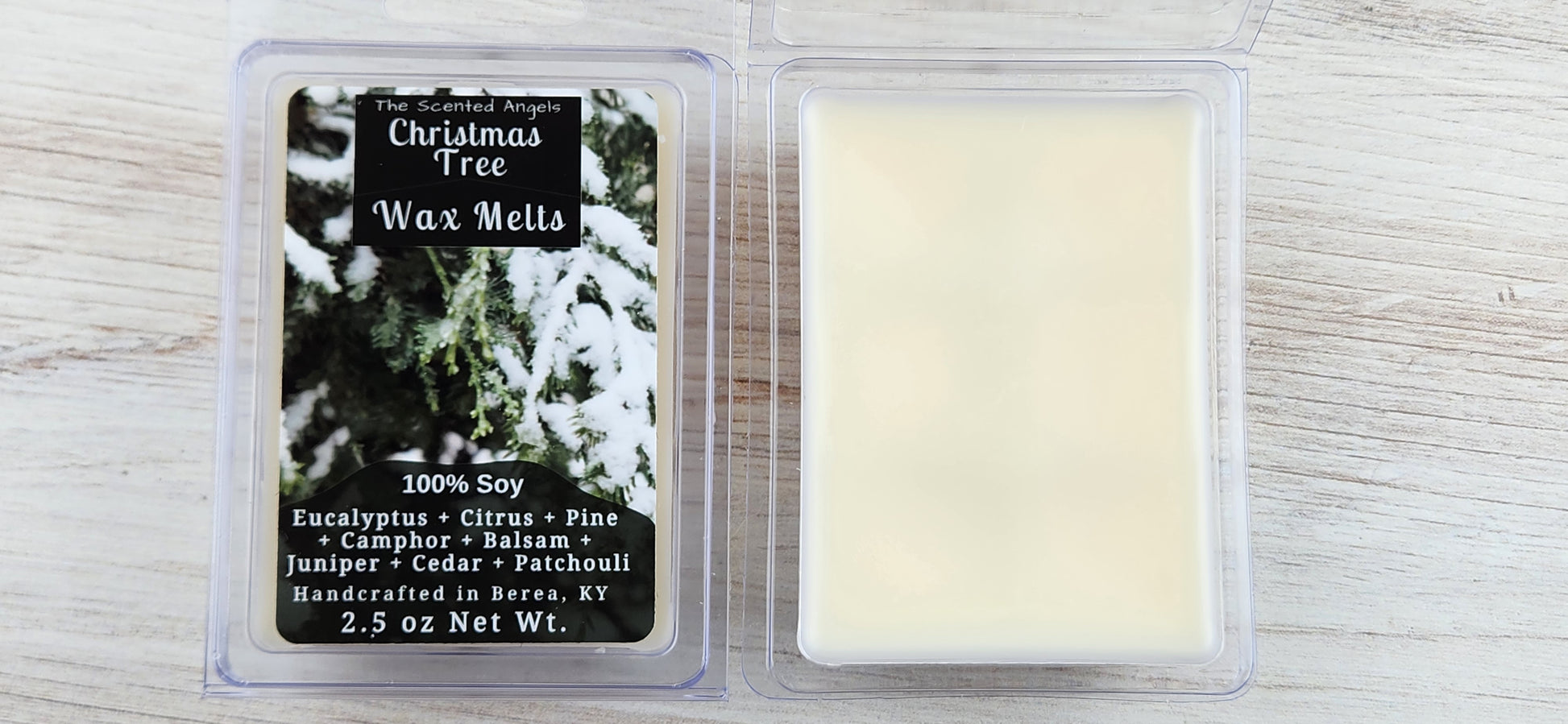 Two wax melt packages with a Christmas tree design on a wooden surface