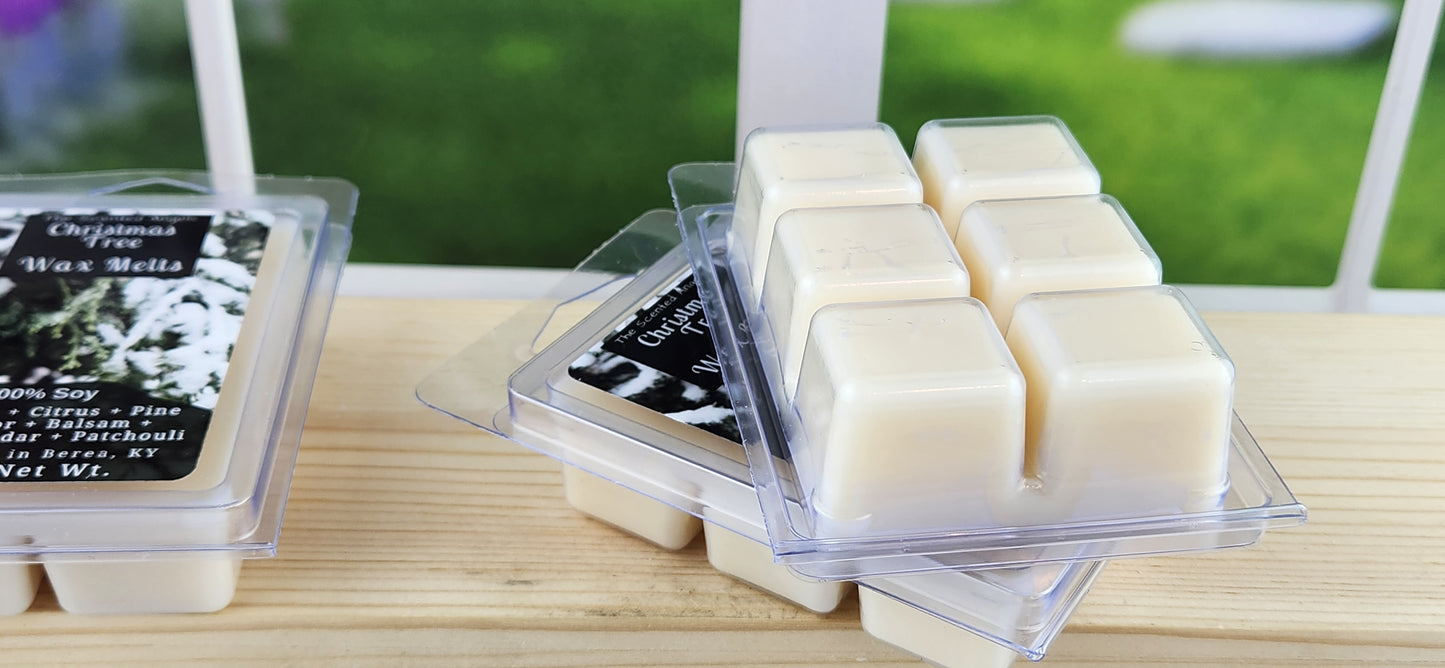 Wax melts in clear packaging on a wooden surface with a blurred green outdoor background