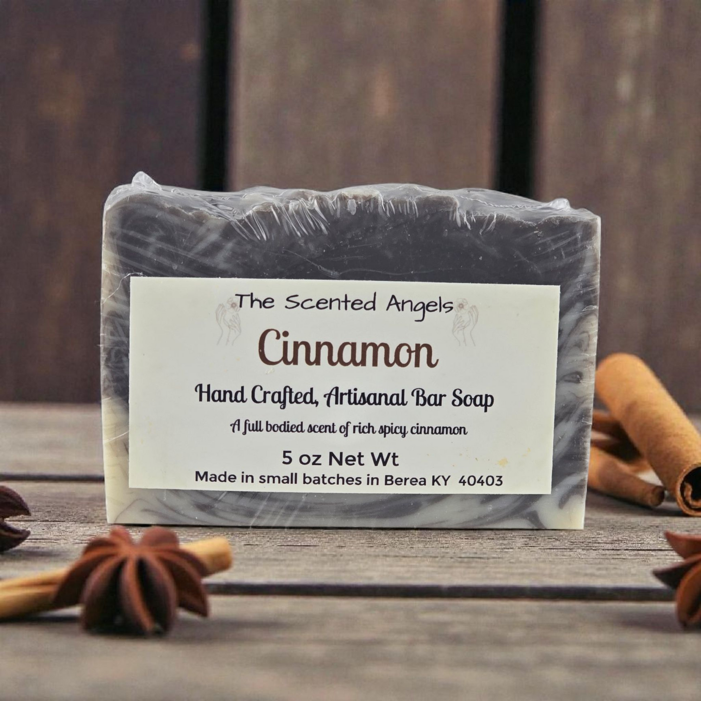Handcrafted cinnamon soap bar with a label on a wooden surface.