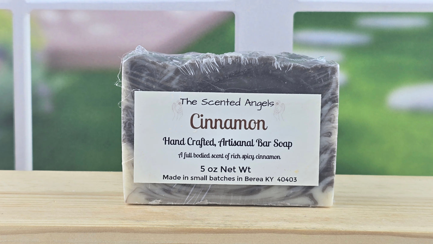 Cinnamon soap bar with a label on a wooden surface, blurred outdoor background