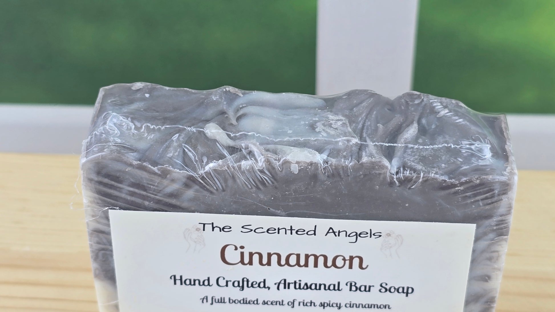 Cinnamon soap bar with a label on a wooden surface close up of top