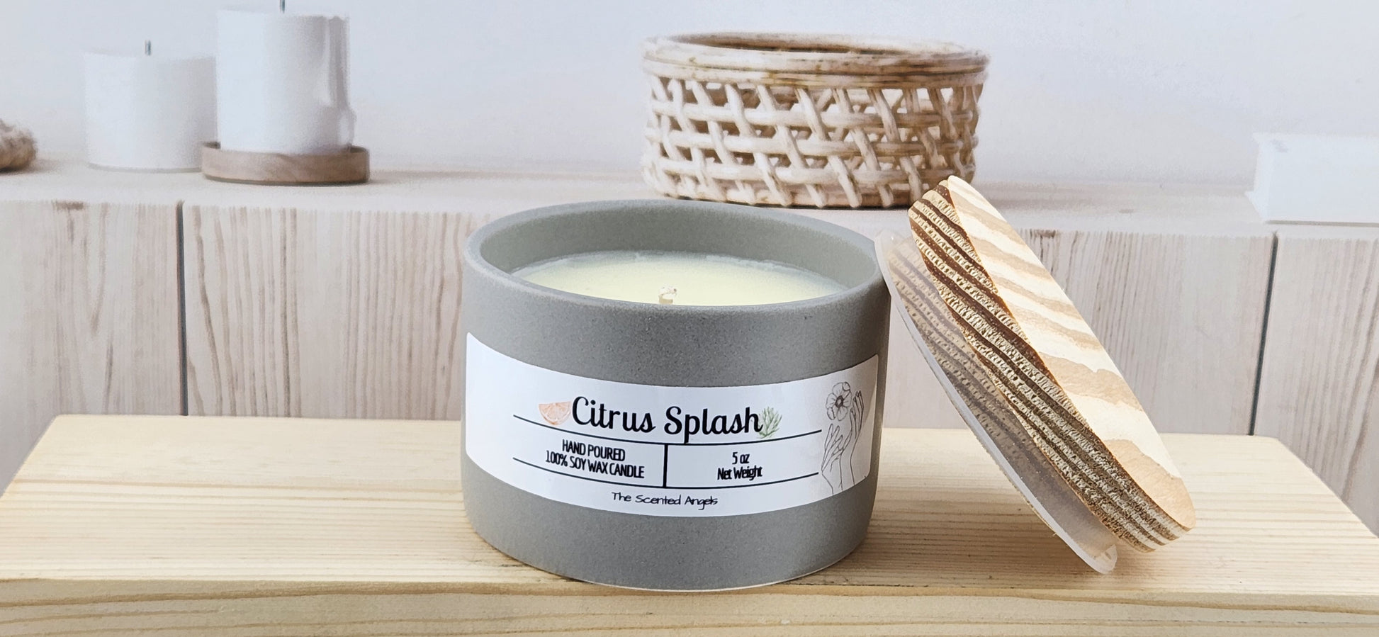 Candle labeled 'Citrus Splash' with a wooden lid on a wooden surface.