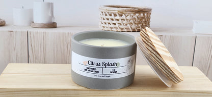 Candle labeled 'Citrus Splash' with a wooden lid on a wooden surface.