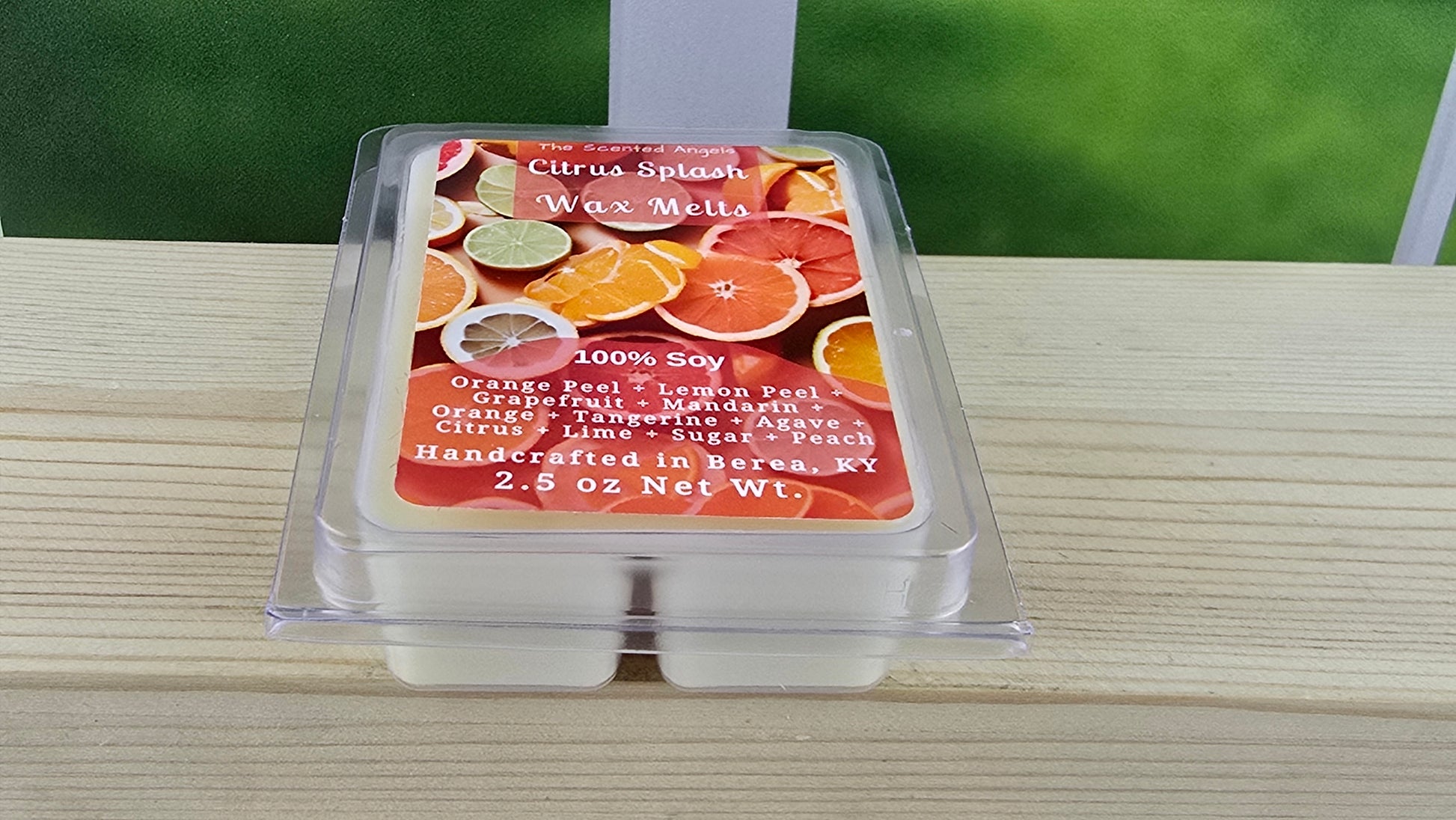 Wax melt container with citrus-themed label on a wooden surface