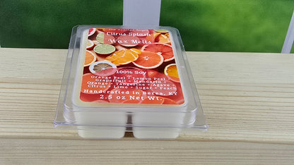 Wax melt container with citrus-themed label on a wooden surface