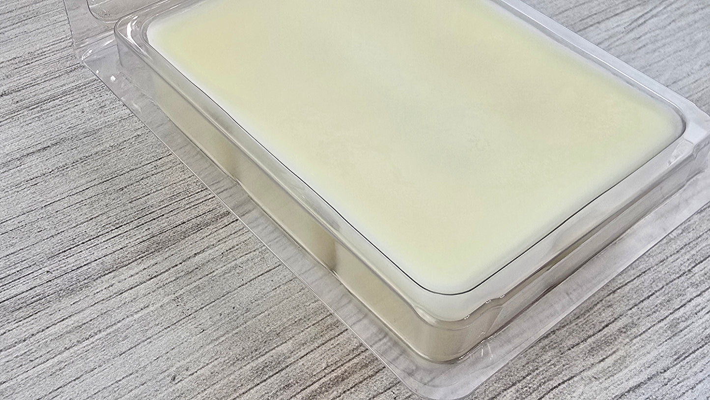 Wax Melts in a clear plastic container on a wooden surface