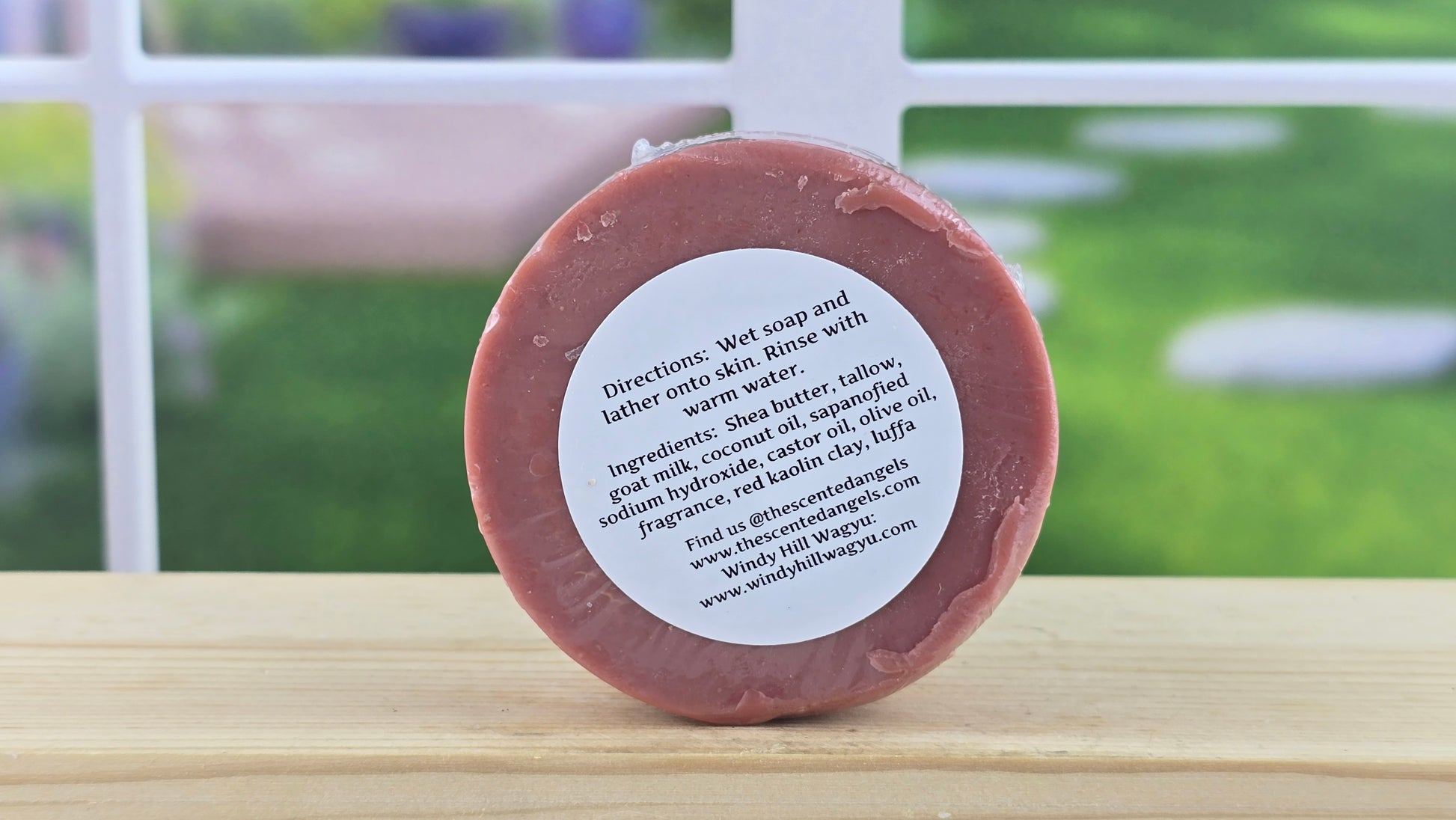 Bar of soap with a label on a wooden surface, outdoor background