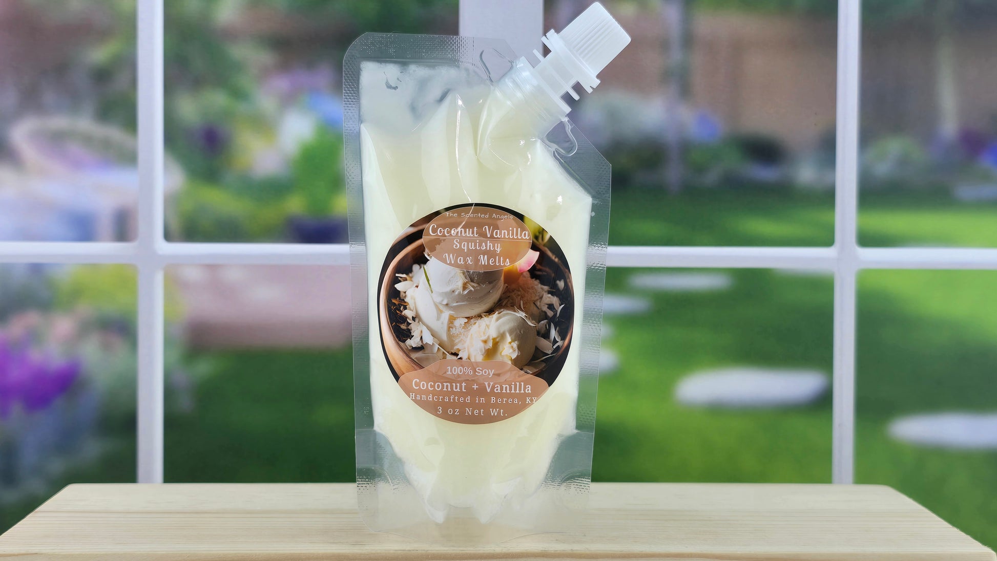 A pouch of handmade coconut vanilla 100% soy squeezy wax melts placed on a wooden stand with a view of a garden through the window.