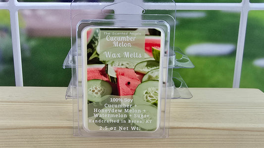 Cucumber Melon wax melt package on a wooden surface with a blurred outdoor background
