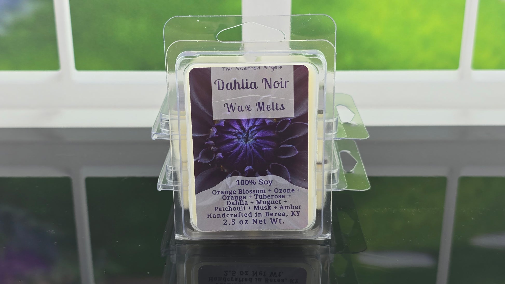 Dahlia Noir wax melts packaging with a purple label on a reflective surface.