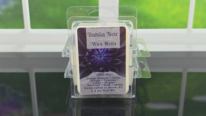 Dahlia Noir wax melts packaging with a purple label on a reflective surface.