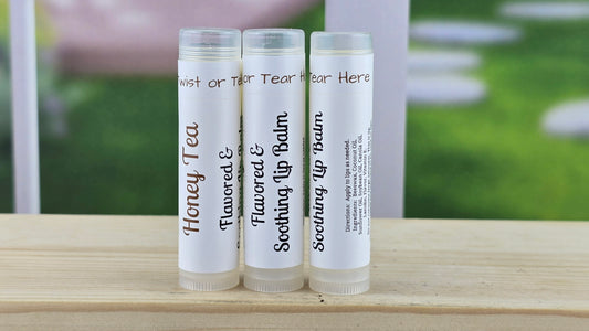 lip balm tubes on a wooden surface with a blurred outdoor background