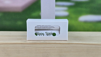 Hippy Lippi product packaging on a wooden surface with a blurred background