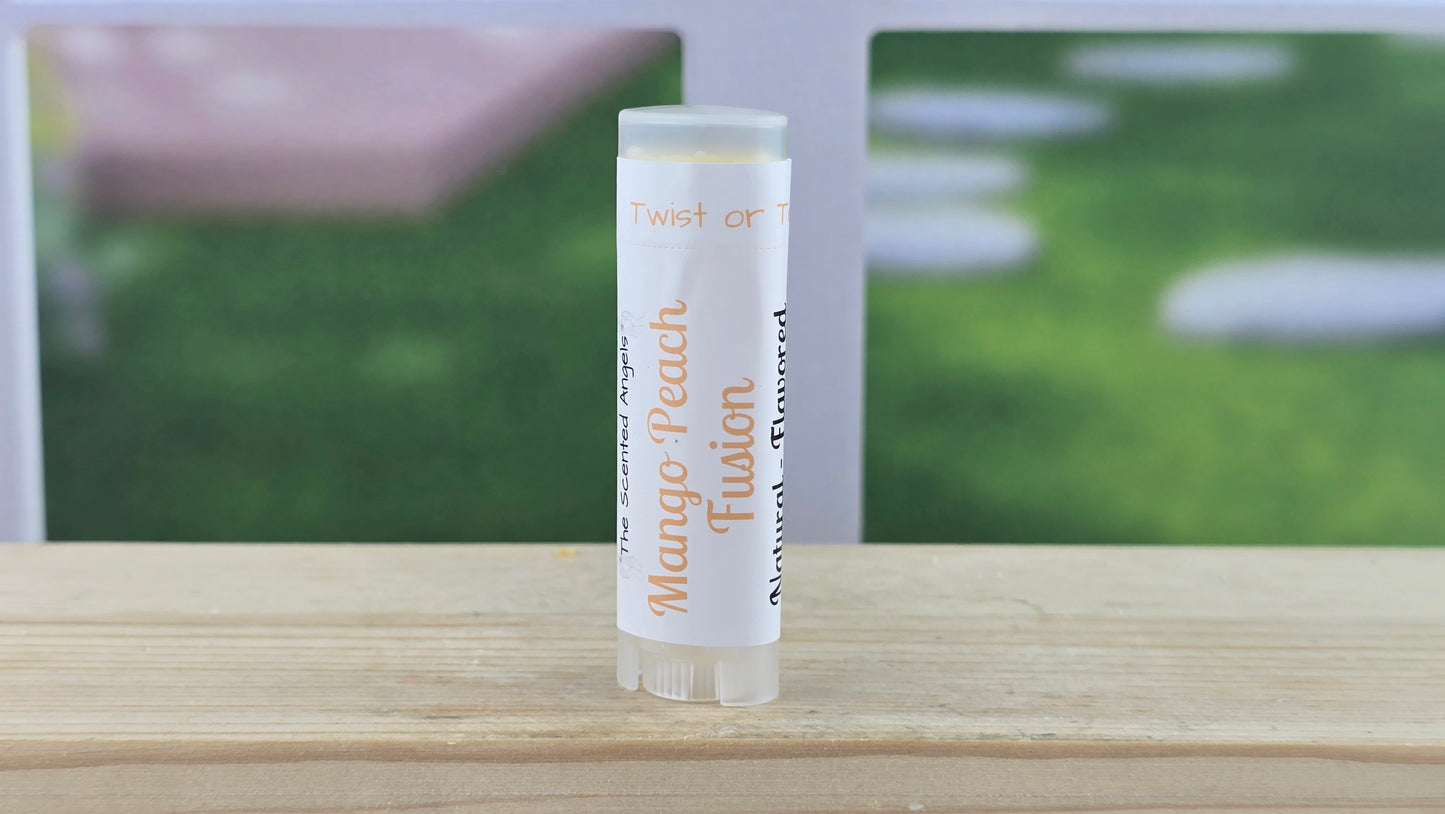 Lip balm tube labeled 'Mango Peach Fusion' on a wooden surface with a blurred outdoor background.