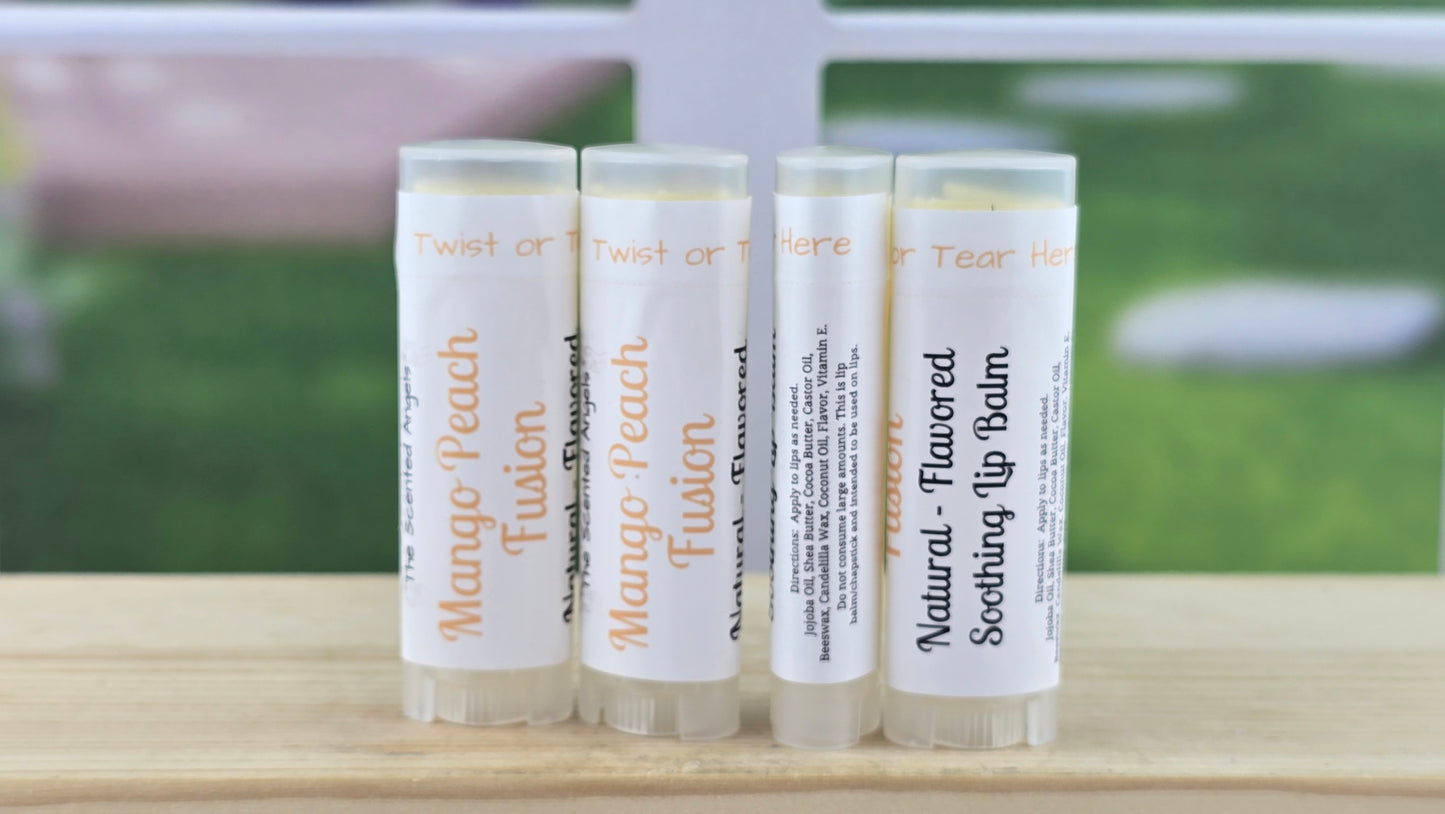 Four mango peach lip balm tubes with labels on a wooden surface
