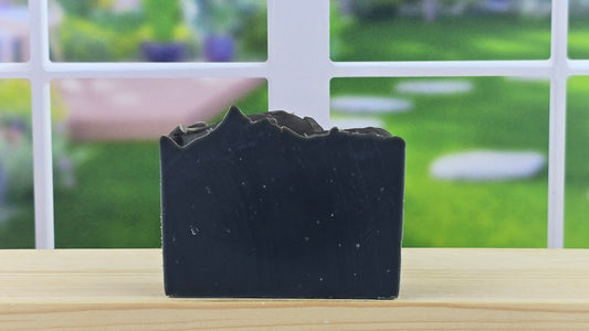 A bar of handmade cold process soap wooden surface with a blurred background.