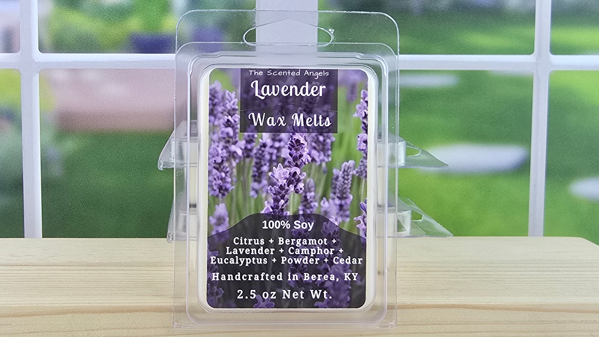 Lavender wax melt packaging with lavender flowers on a wooden surface.