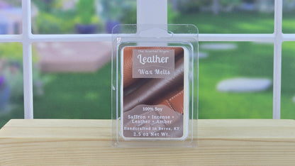 Packaged leather wax melts on a wooden surface with a blurred outdoor background