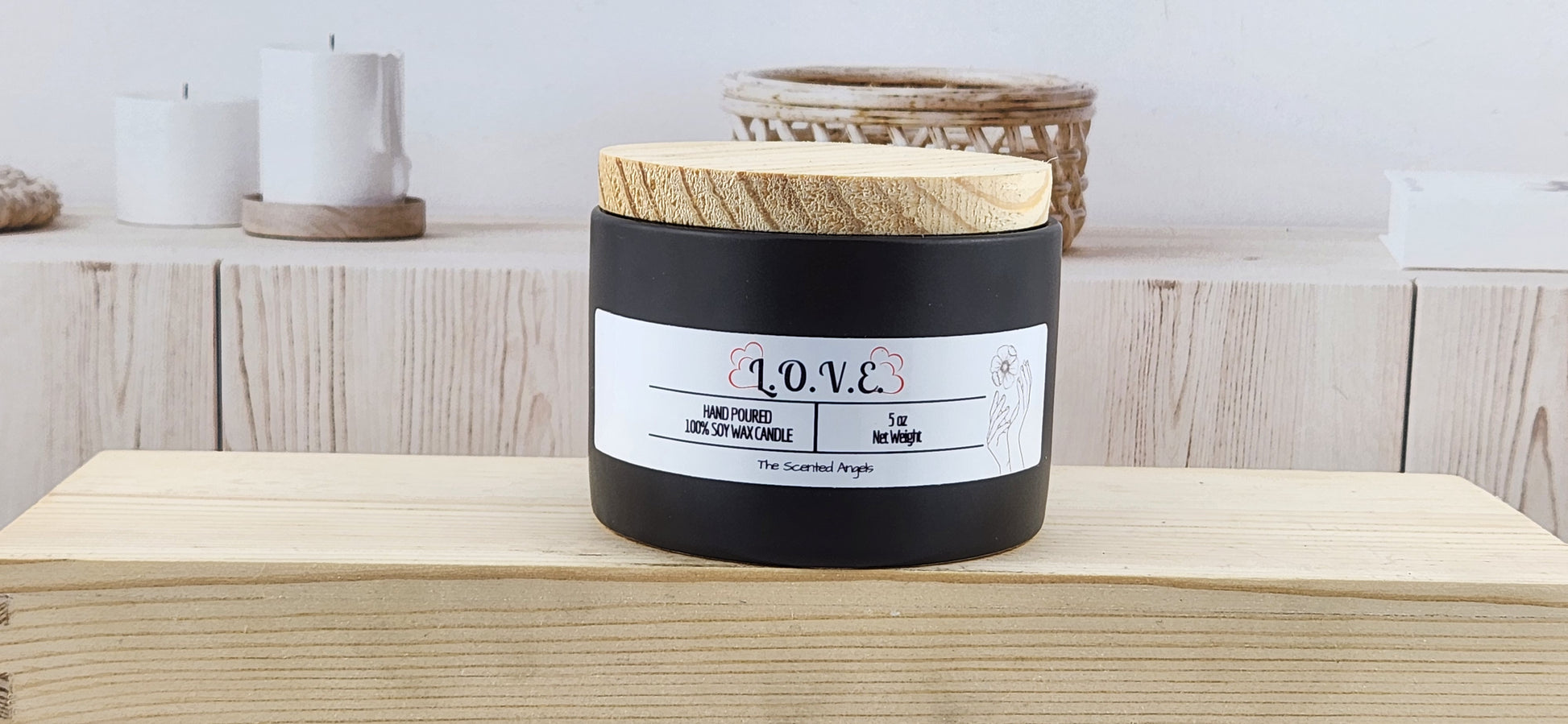 Black candle with wooden lid on a wooden surface, with a blurred background