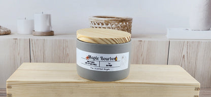 Candle jar with wooden lid on a wooden surface, with 'Maple Bourdon' on label
