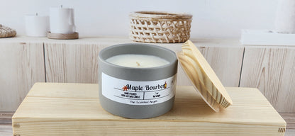 Candle labeled 'Maple Bourbon' on a wooden surface with a blurred background