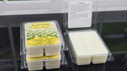 Meadowlight wax melts in packaging with a warning label on a black surface.
