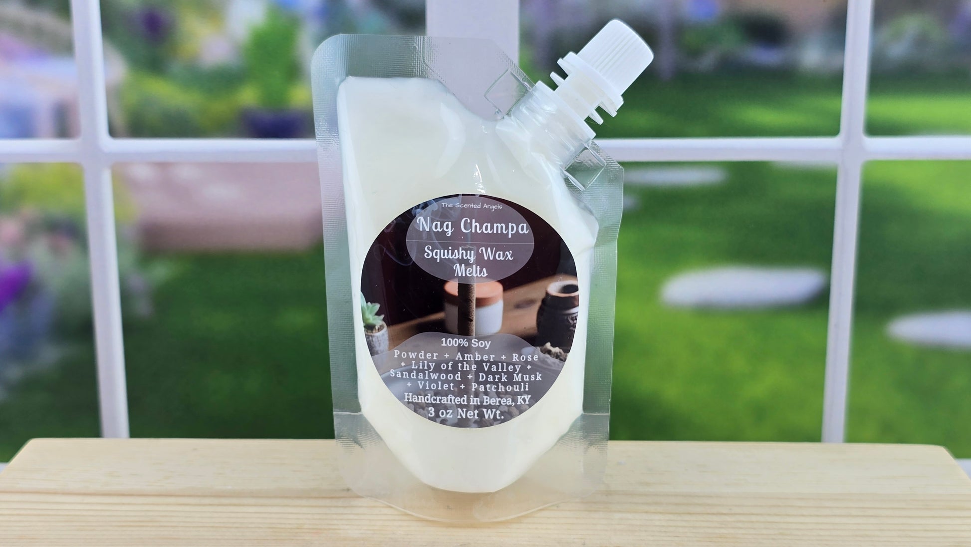 A clear plastic pouch containing white squeezable wax melts with a label that reads 'Nag Champa', with a blurred background.