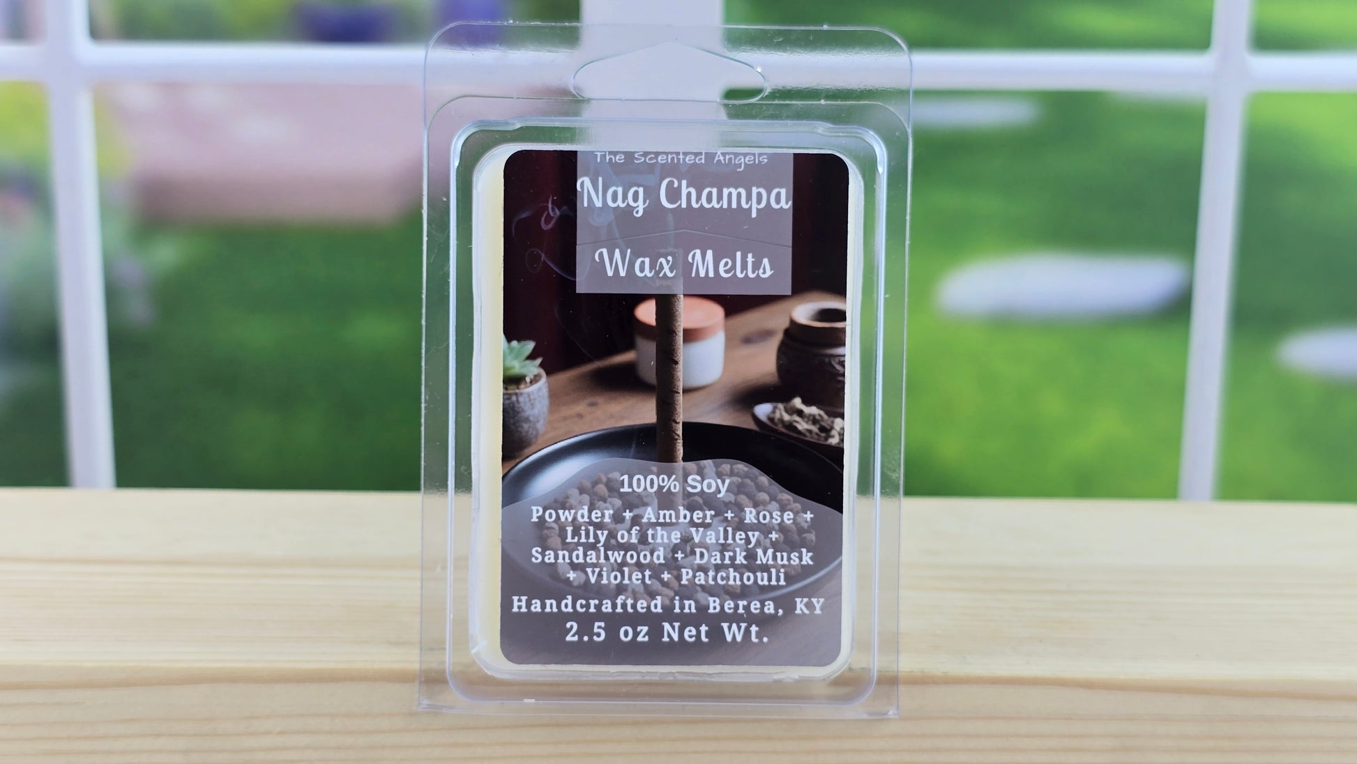 Nag Champa wax melt package on a wooden surface with a blurred outdoor background