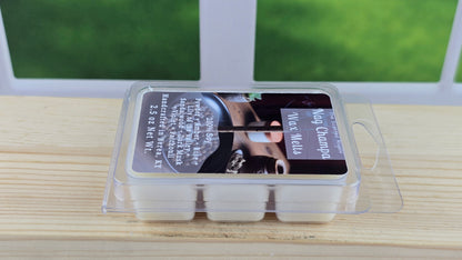 Packaged wax melts on a wooden surface with a window in the background