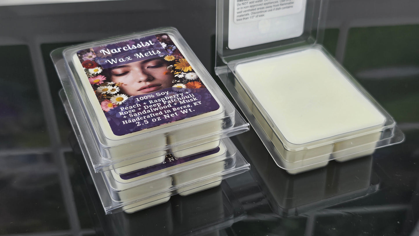 Wax melts in clear packaging with a visible label on a reflective surface.