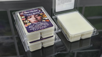 Wax melts in clear packaging with a visible label on a reflective surface.