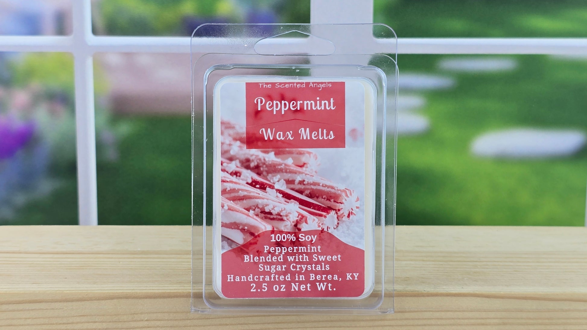 Peppermint wax melts packaging on a wooden surface with a blurred outdoor background