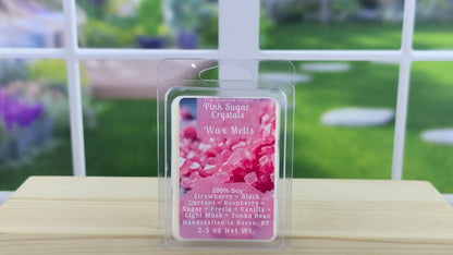 Pink sugar scrub wax melt packaging on a wooden surface with a blurred outdoor background