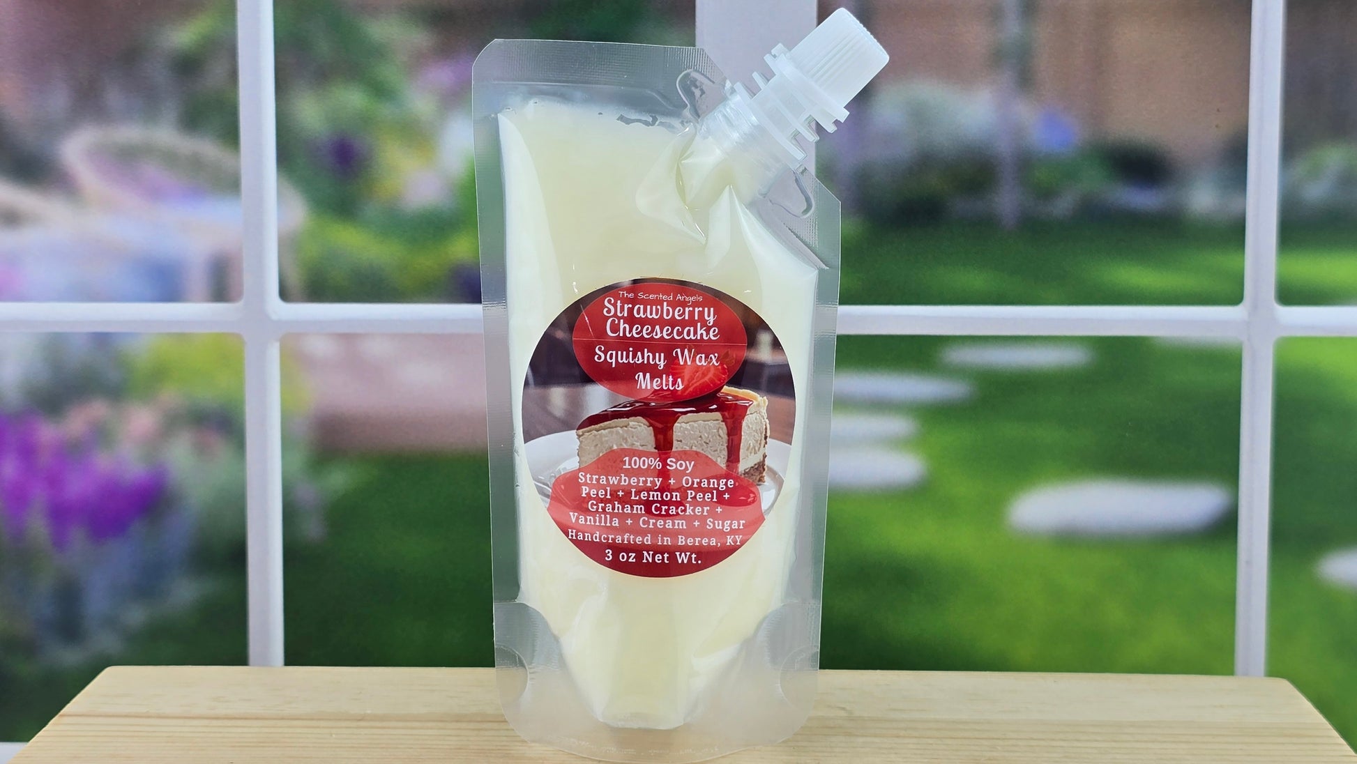 Packaged Strawberry Cheesecake Soy Wax Melts on a wooden surface with a garden background