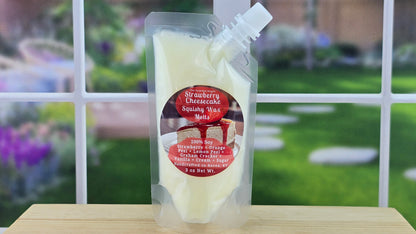 Packaged Strawberry Cheesecake Soy Wax Melts on a wooden surface with a garden background