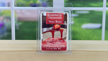 Packaging of Strawberry Cheesecake wax melts on a wooden surface with a blurred outdoor background.