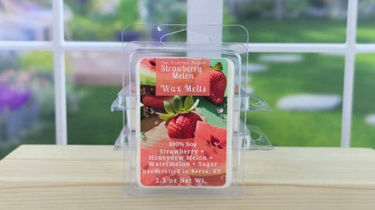Strawberry Melon wax melt packaging on a wooden surface with a blurred outdoor background