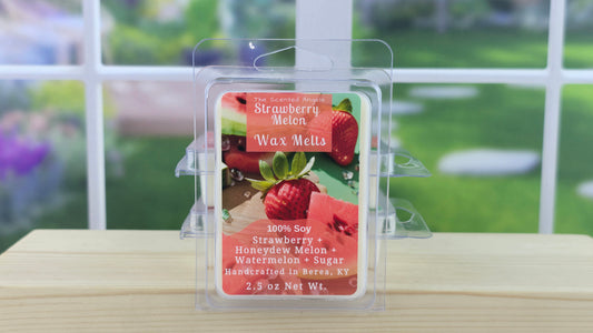 Strawberry Melon wax melt packaging on a wooden surface with a blurred outdoor background
