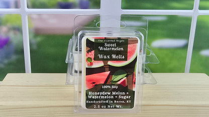 Sweet Watermelon wax melt packaging on a wooden surface with a blurred outdoor background